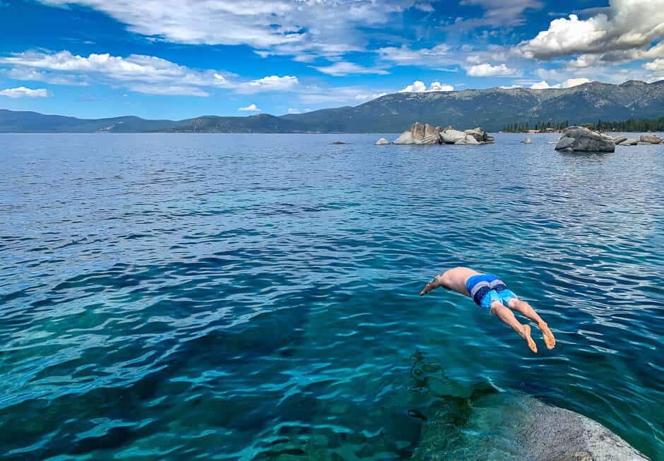 Man diving into blue Lake Tahoe, enjoying beautiful California nature