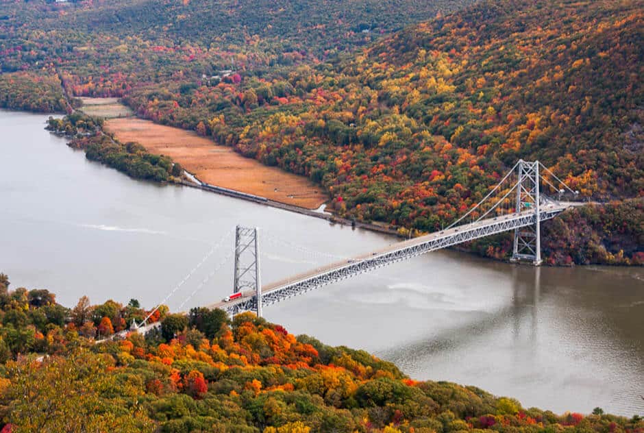 Suspension bridge over river and fall foliage in Hudson Valley, New York a popular fall vacation in the U.S.