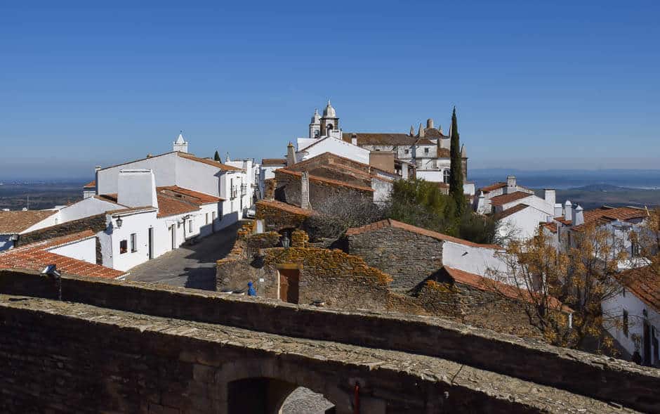 View of a medieval hilltop town with brick and red roofs in Monsaraz, Portugal