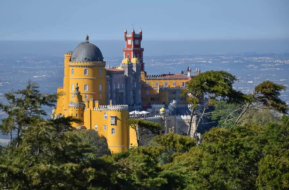 A colourful yellow and red castle on a hill in Sintra National Park, Portugal