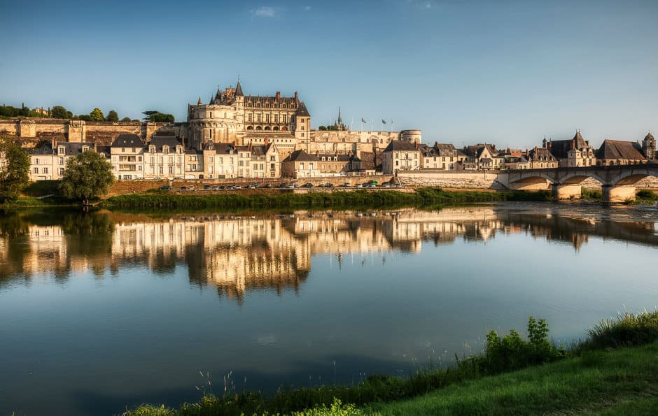 A big castle overlooking a the town of Amboise and a river in France