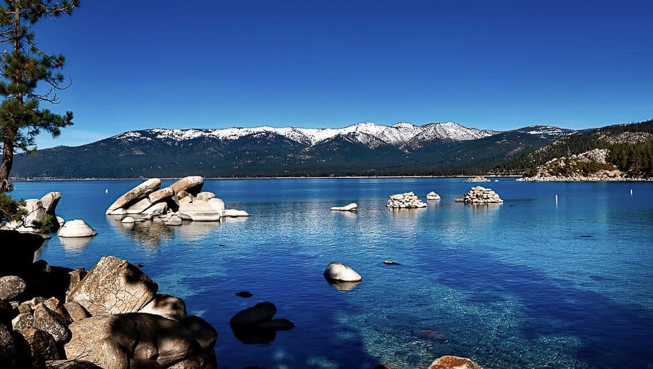 Deep blue lake with snow capped mountains in the background