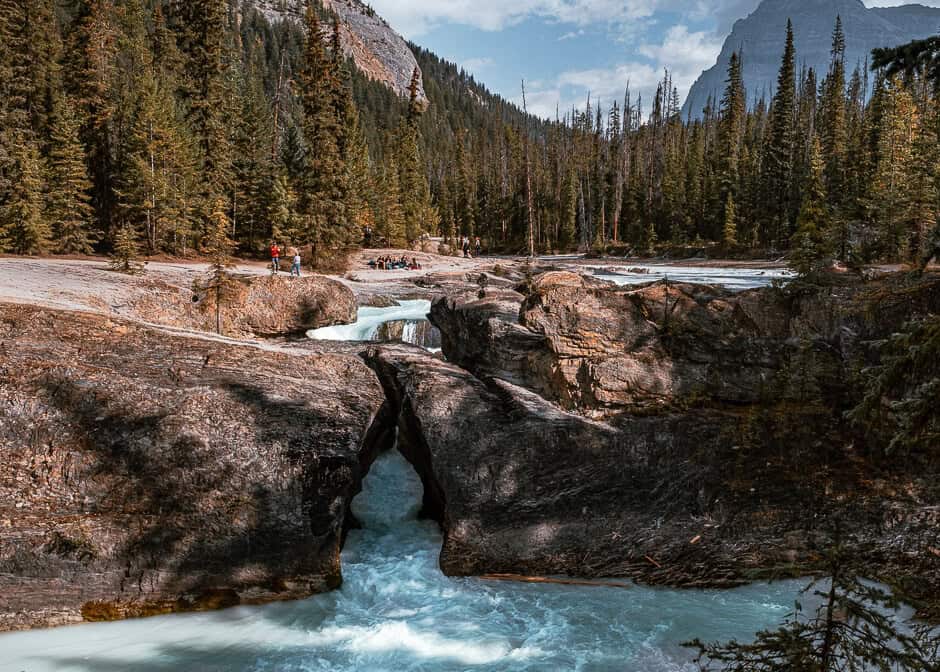 A glacial stream running through large rocks with a mountain backdrop in British Columbia, Canada