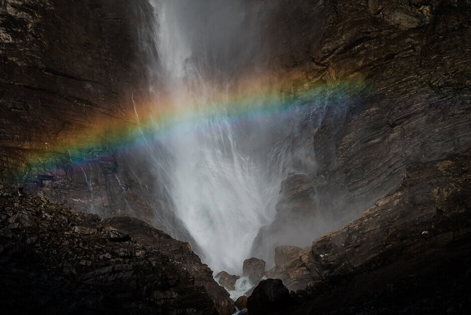 A strong waterfall with a rainbow across it in Yoho National Park, Canada